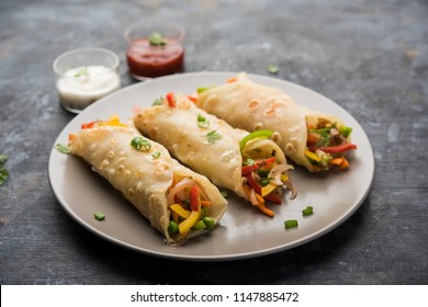 Indian Veg chapati Wrap / Kathi Roll, served in a plate with sauce over moody background. selective focus