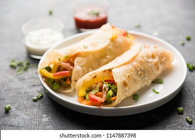 Indian Veg chapati Wrap / Kathi Roll, served in a plate with sauce over moody background. selective focus
