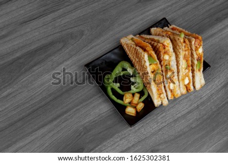 Indian veg grilled sandwich or paneer sandwich served in black dish with capsicum and fried paneer cube. Selective focus