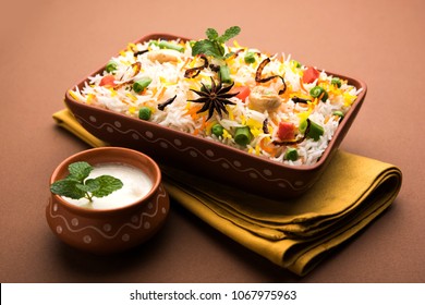 Indian Vegetable Pulav or Biryani made using Basmati Rice, served in terracotta bowl. selective focus
