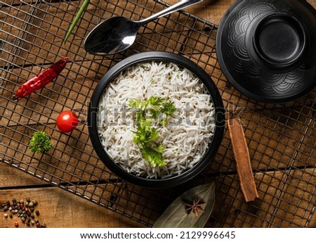 Indian Vegetable Pulav or Biryani made using Basmati Rice, served in a wooden bowl with yogurt. selective focus