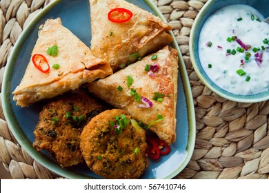 Indian Vegetable snacks -  pakora, samosa, onion bhaji with coriander.