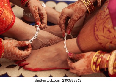 Indian Wedding Concept. Two women at an Indian wedding, wearing Silver anklets (Payal) and showing off their feet.