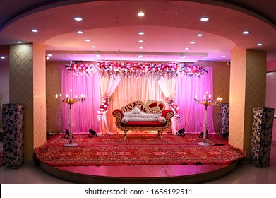 Indian Wedding Or Reception Venue With A Bride - Groom Chair Placed In Middle Of The Stage.