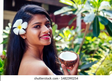 Indian Woman Applying Coconut Oil Dark Brunette Long Hair In A Hand On Green Summer Park Nature Tropical