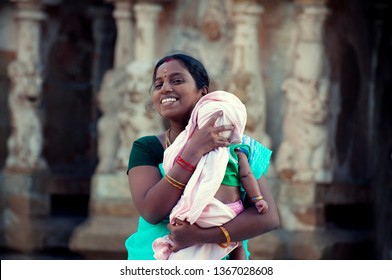 Indian woman with child on her arms. Happy and smiling young mother with her newborn kid
