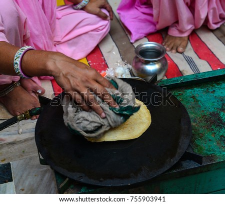 Indian woman cooking traditional bread (roti, chapati) at street market.