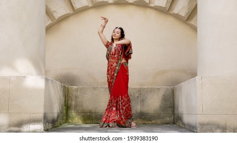 Indian woman dance streets ancient architecture city India dressed in red Sari  decorated and traditional ornaments   Mehendi patterns henna drawings hands 