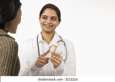 Indian Woman Doctor Explaining Medication To Asian Woman Patient.