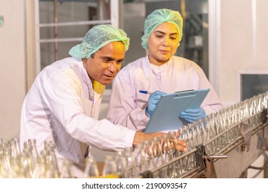 Indian Woman Engineers A Fruit Drink Factory In Glass Bottles Inspecting Glass Bottle Packaging For Fruit Juice Drinks By Wearing Tight Protective Clothing To Get The Best Quality Before Packing Juice