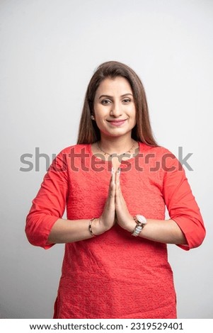Indian woman giving namaste or welcome gesture on white background