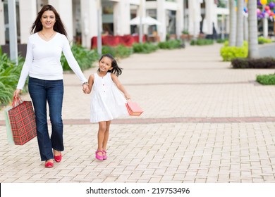 Indian Woman And Her Little Daughter With Shopping Bags Walking Along The Street