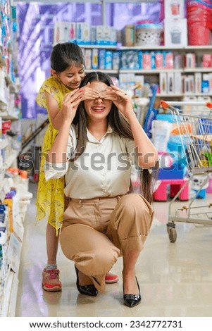 Indian woman and her little daughter fun to each other at grocery shop.