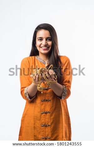 Indian woman holding gold jewelry, ornaments - Asset or Gold Loan concept