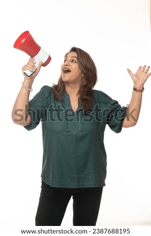 Indian woman holding a megaphone isolated. Copyspace against white studio background.