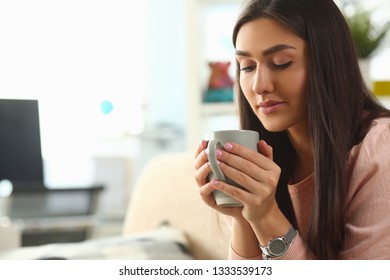 Indian woman holds mug her hand, smiles and lies on the sofa. Work at home education concept. - Shutterstock ID 1333539173