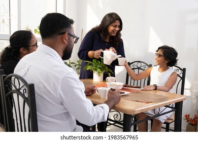 An Indian Woman Hosting And Offering Tea For Her Guests.