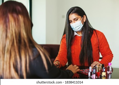Indian woman in a mask getting manicure and other beauty services at home