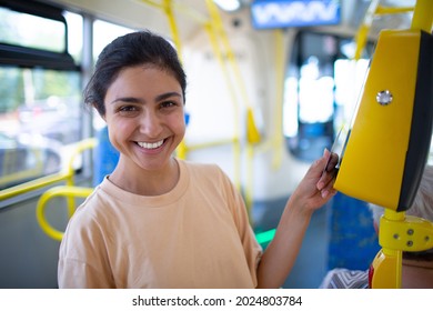 Indian Woman paying conctactless with card for public transport bus or tram