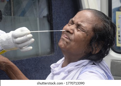 Indian Woman Reacts As A Health Worker Collects Swab Samples For COVID 19 Testing At A Mobile Collection Van On July 1,2020 In Calcutta, India.