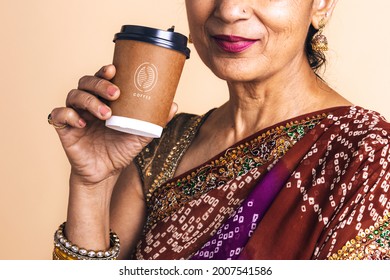 Indian woman in a saree drinking coffee from a paper cup mockup