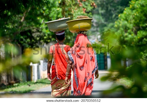 Indian woman in Sari carries a\
large basket of brick on her head.  Indian women worker or\
labour.