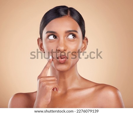 Indian woman, skincare and hand for thinking in studio with face, beauty and pouting by background. Young asian model, gen z girl and cosmetics for natural skin glow, aesthetic or happiness for idea