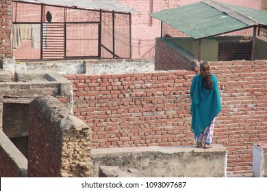 Indian Woman Stands Alone On Top Of The Wall At Sunny Day.