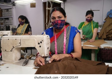 Indian woman textile workers with protective face mask on production line - Powered by Shutterstock