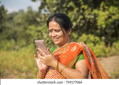 Indian woman in traditional cloth using smartphone at outdoor. Changing human life concept.