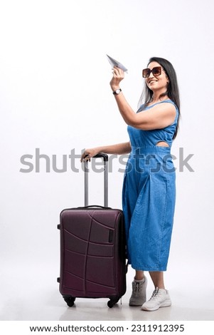 Indian woman traveler carrying suitcase on white background.
