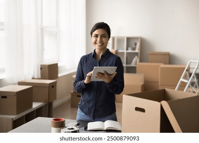 Indian woman using her tablet to check inventory, product availability in warehouse, track incoming shipments busy in stock management. Portrait of happy, successful small business owner - Powered by Shutterstock