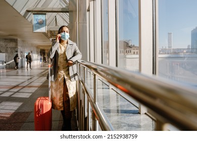 Indian Woman Wearing Face Mask Talking On Mobile Phone In Airport Indoors