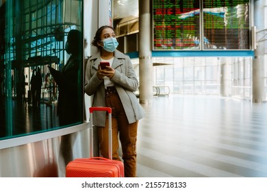 Indian Woman Wearing Face Mask Using Mobile Phone At Train Station Indoors