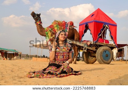 An Indian woman wearing a Rajasthani traditional dress called Ghagra,choli at thar desert, Pushkar, Rajasthan, India, and enjoying her vacation.