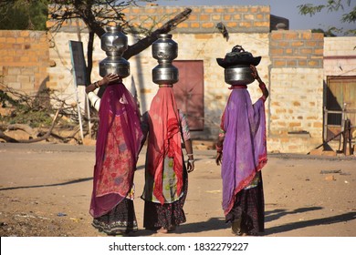 Indian Women Carrying Heavy Jugs Of Water On Their Head