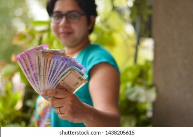 Indian Women Holding All The Colorful New Released Indian Rupees Currency Notes After Demonetisation In Denominations 10,50,100, 200, 500, Pink 2000 In Her Hands With Her Blur Face In The Background