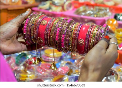 Indian Women holding a bunch of metal bangles for buying
