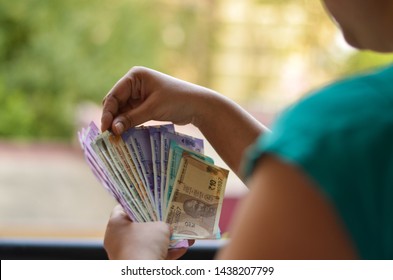 Indian Women Holding & Counting All The Colorful New Released Indian Rupees Currency Notes In Her Hands After Demonetisation In Denominations 10, 50, Purple 100, 200, Green 500, Pink 2000 In Her Hands