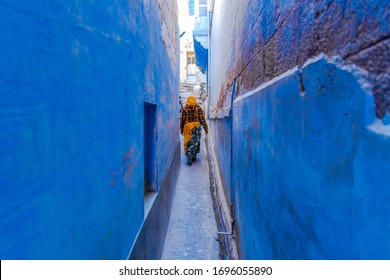 Indian women in traditonal india dressed Indian Saree walking through the narrow blue streets of the blue city of Jodhpur, Rajasthan, India.