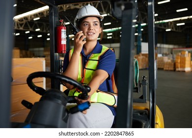 Indian worker driving a forklift and using walkie talkie in warehouse storage - Shutterstock ID 2202847865