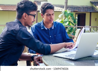 Indian young business people businessman freelancer working outdoors chaise lounge on the beach with laptop.two successful friends freelancing surfing remote work summer vacation in tropical paradise. - Shutterstock ID 1369476026