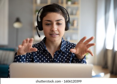 Indian young business woman student teacher tutor wear wireless headset video conference calling on laptop computer talk by webcam learn teach in online chat, distance webinar online teaching concept - Shutterstock ID 1606120399