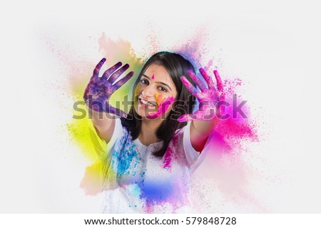 indian young girl showing colourful palm and celebrating holi with colour splash