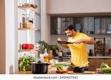 Indian young handsome man in kitchen while cooking,  - Powered by Shutterstock