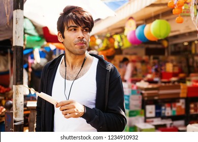 Indian Young Man Eating Kulfi (traditional Indian Ice-cream) In A Market