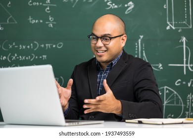Indian young teacher man sitting teaching online video conference live stream by laptop. Asian teacher teaching mathematics class webinar online for students learning.