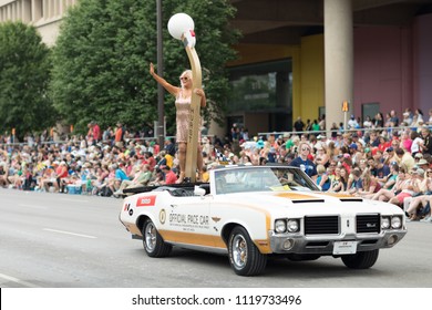 Indianapolis, Indiana, USA - May 26, 2018, Linda Vaughn racing beauty queen, on top of a plataform on the back of a classic car, going down the street at the Indy 500 Parade