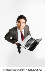 Indian/asian Businessman Holding Laptop Over White Background And Looking Upward Towards Camera, A View From Top Also Known As Bird's Eye View