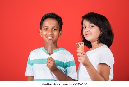 Indian/Asian Cute Kids Eating Ice Cream In Cone Or Candy. Isolated Over Colourful Background